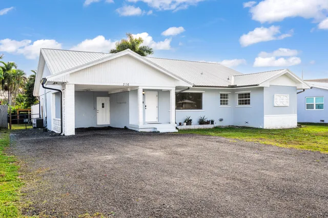 a view of a white house with a yard and garage