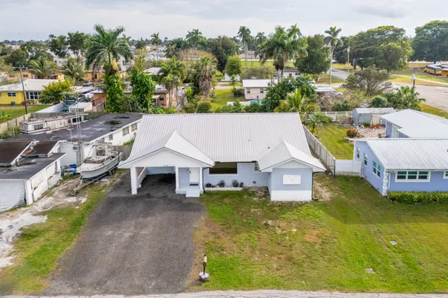 a aerial view of a house with swimming pool and next to a yard