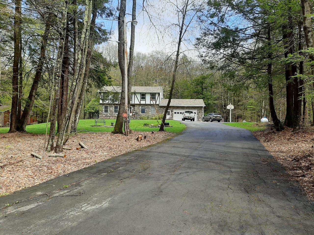 29 Deforest Road Montauk, NY 11954 - Photo 1 of 1 View of front facade with a garage, stone siding, and a front lawn