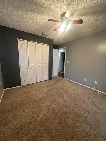 an empty room with windows and fan