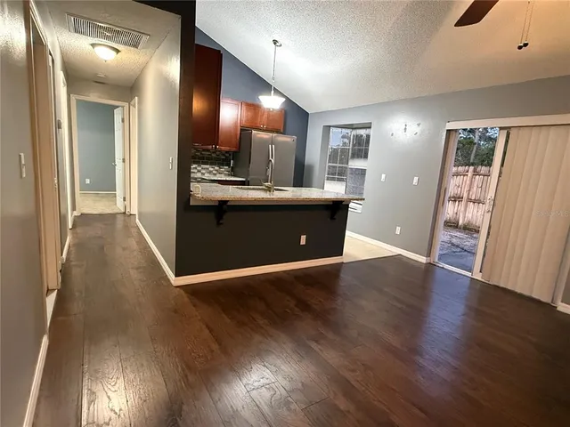 a view of a kitchen with wooden floor and a large window