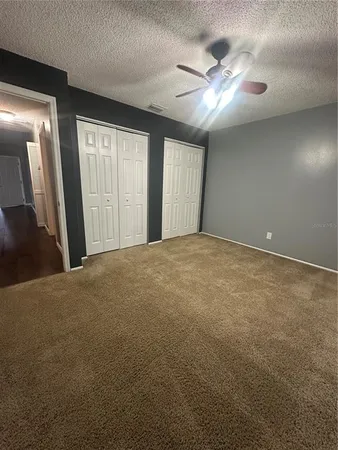 a view of a livingroom with a ceiling fan and window