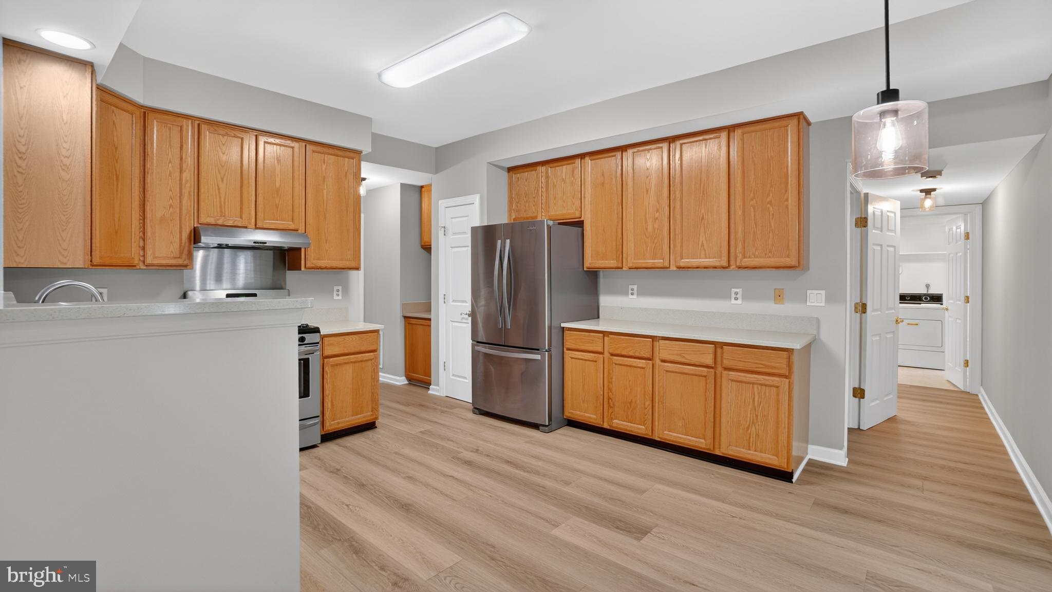 2812 Brite Court Crofton, MD 21114 - Photo 16 of 55 a kitchen with stainless steel appliances granite countertop a refrigerator a sink dishwasher and wooden cabinets with wooden floor