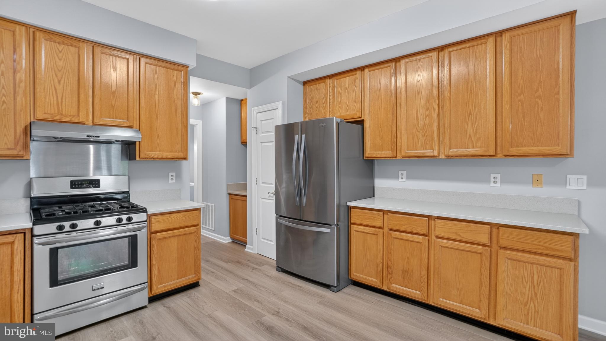 2812 Brite Court Crofton, MD 21114 - Photo 19 of 55 a kitchen with granite countertop wooden floors stainless steel appliances and sink