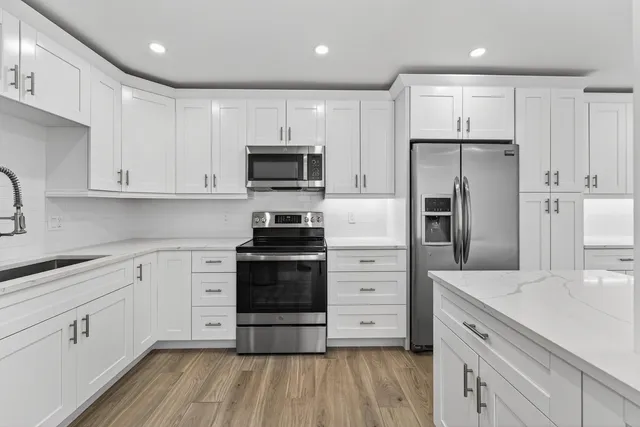 a kitchen with stainless steel appliances a refrigerator sink and microwave