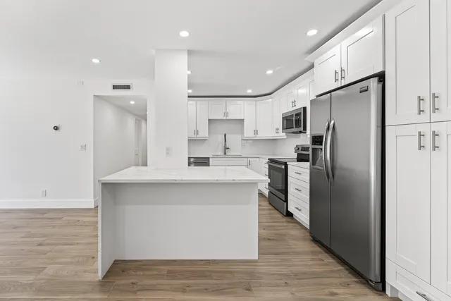 a kitchen with white cabinets and stainless steel appliances