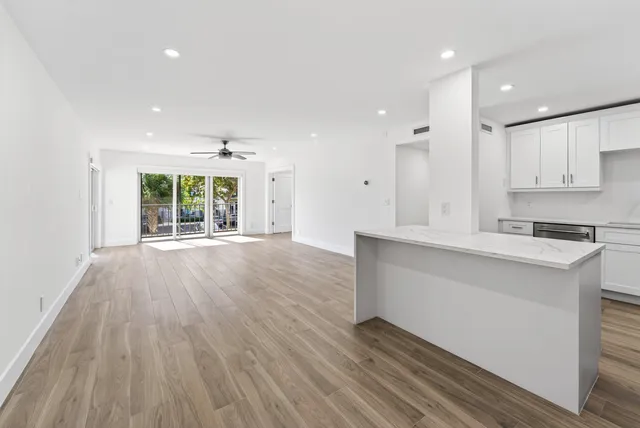a view of a kitchen with a sink and dishwasher with wooden floor