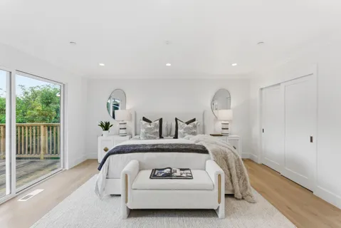 a bed sitting in a spacious bedroom next to a window