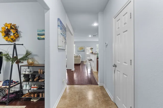 a view of a hallway with wooden floor and windows