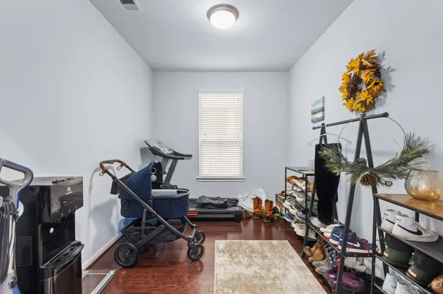 a room with gym equipment and wooden floor