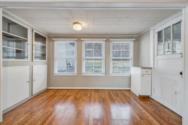 a view of empty room with a window and wooden floor
