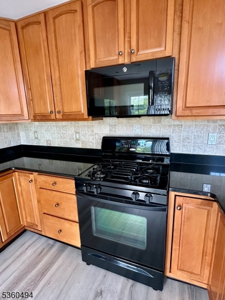 35 Magnolia Way, Unit 35 North Haledon, NJ 07508 - Photo 16 of 34 a kitchen with granite countertop wooden cabinets and a stove top oven