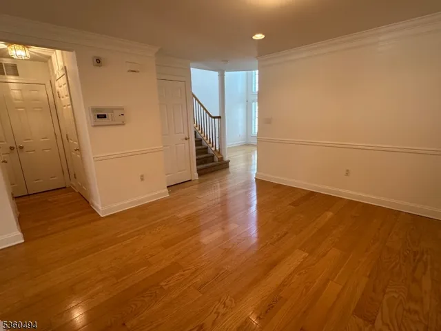 a view of a room with wooden floor and white walls