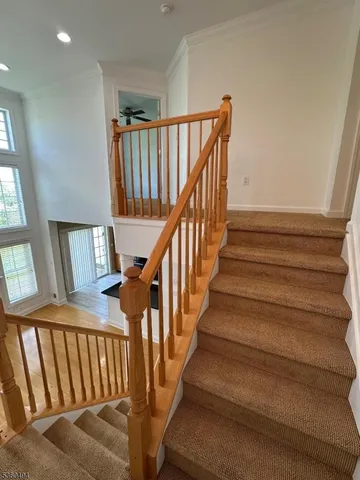 a view of staircase with lots of frames on wall and a window