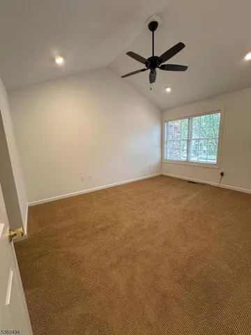 an empty room with a ceiling fan and window
