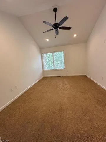 an empty room with a window and a fan