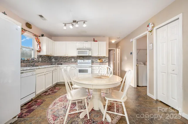a kitchen with a table chairs refrigerator and cabinets