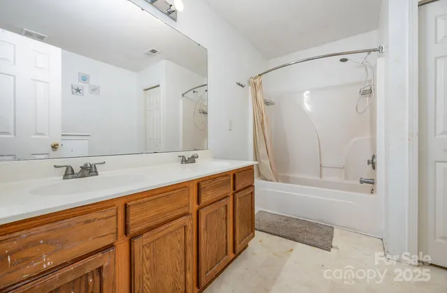 a bathroom with a tub sink and mirror