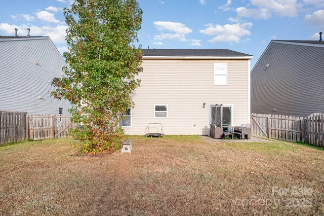 a view of a house with backyard and a tree