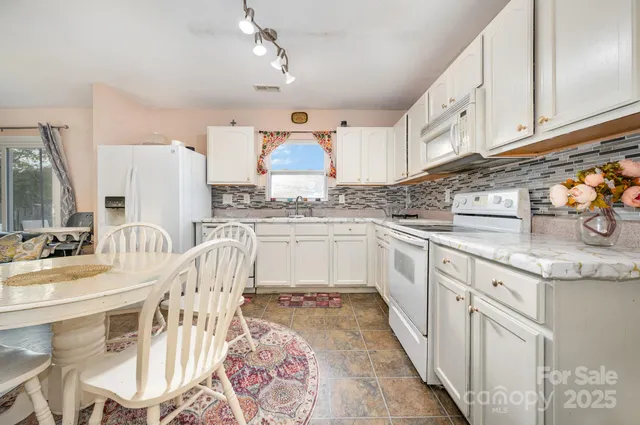 a kitchen with granite countertop a sink a counter space cabinets and stainless steel appliances