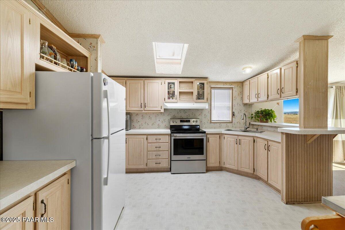 24725 North Patricia Road Paulden, AZ 86334 - Photo 11 of 36 a kitchen with granite countertop a refrigerator stove top oven and sink