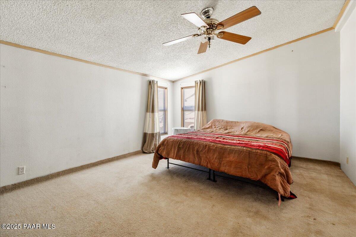 24725 North Patricia Road Paulden, AZ 86334 - Photo 18 of 36 a spacious bedroom with a bed and a ceiling fan