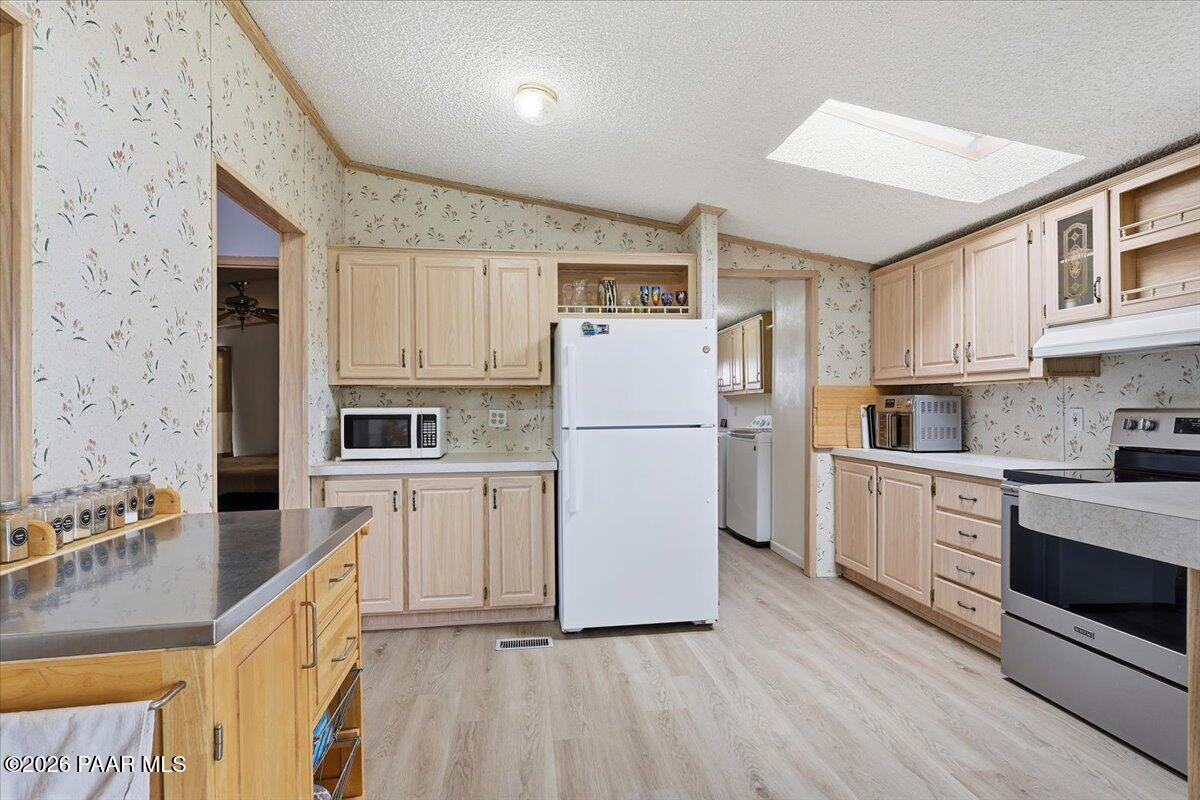 24725 North Patricia Road Paulden, AZ 86334 - Photo 9 of 30 a kitchen with white cabinets and white appliances