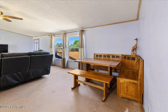 a view of a living room and kitchen with furniture and a large window