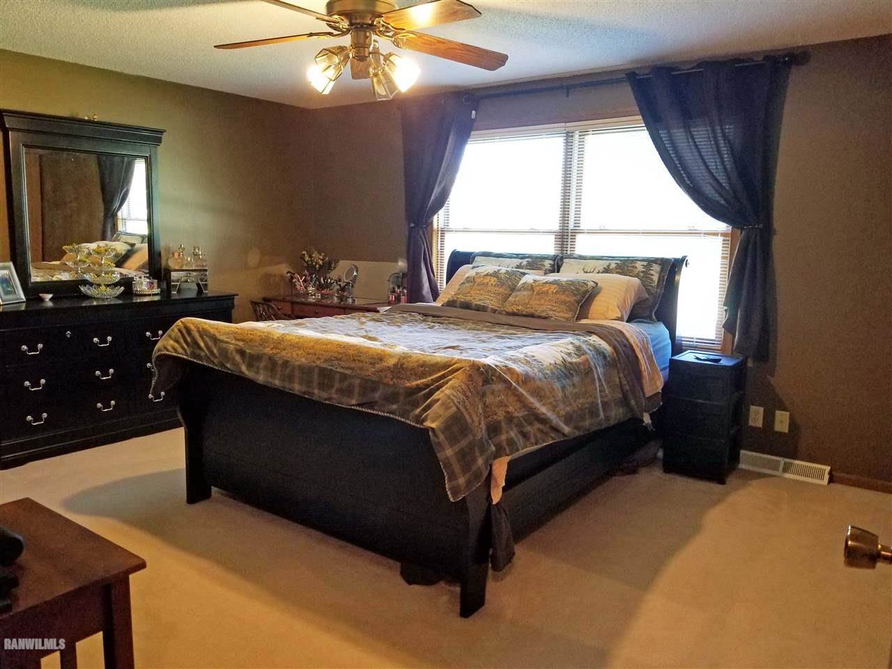 202 West Division Road Shannon, IL 61078 - Photo 11 of 14 a bedroom with a bed and a chandelier