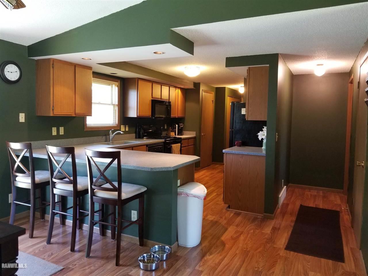 202 West Division Road Shannon, IL 61078 - Photo 6 of 14 a kitchen with stainless steel appliances granite countertop a table chairs and a wooden floor