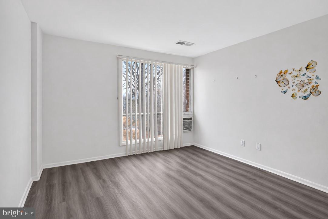 7957 Riggs Road, Unit 11 Hyattsville, MD 20783 - Photo 11 of 19 an empty room with wooden floor and windows