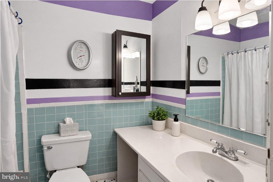 7957 Riggs Road, Unit 11 Hyattsville, MD 20783 - Photo 16 of 19 a bathroom with a toilet sink and mirror