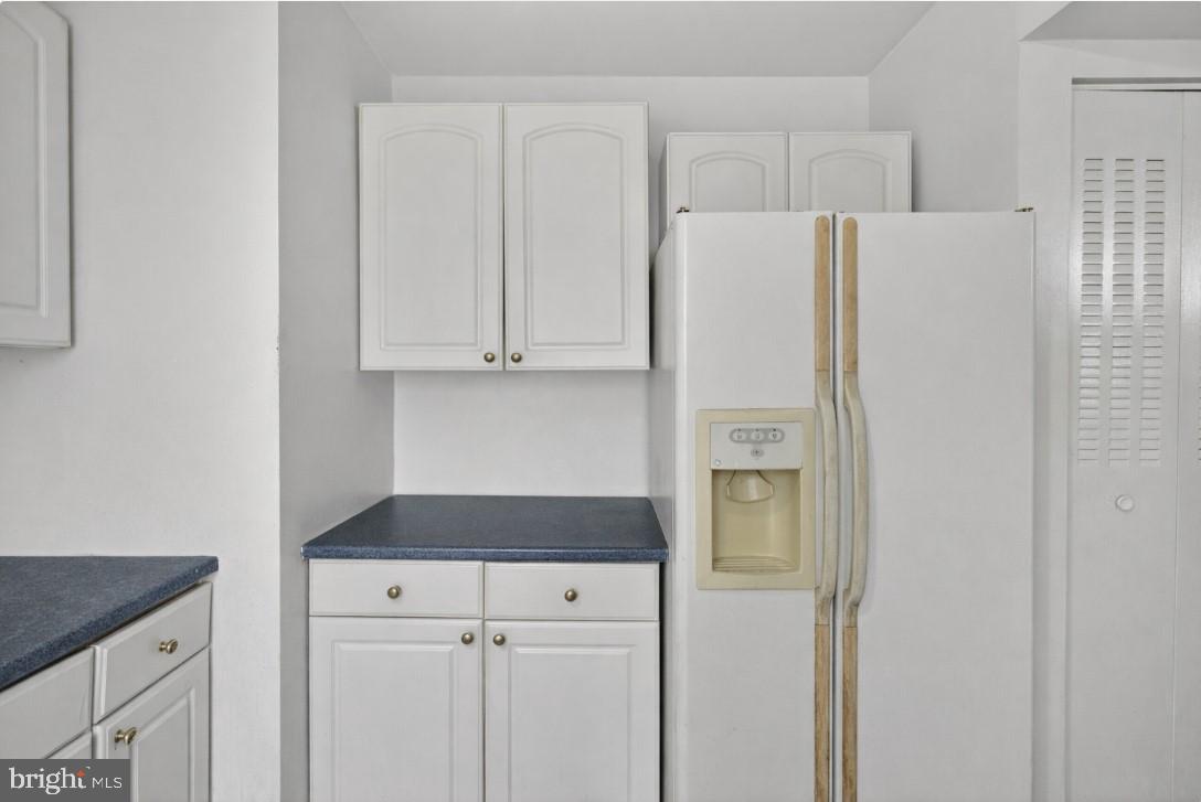7957 Riggs Road, Unit 11 Hyattsville, MD 20783 - Photo 2 of 19 a kitchen with a refrigerator and cabinets