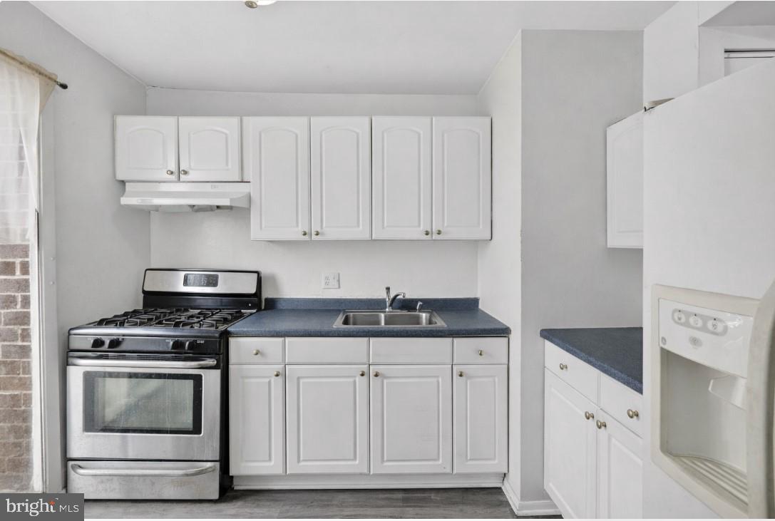 7957 Riggs Road, Unit 11 Hyattsville, MD 20783 - Photo 3 of 19 a kitchen with granite countertop white cabinets and stainless steel appliances