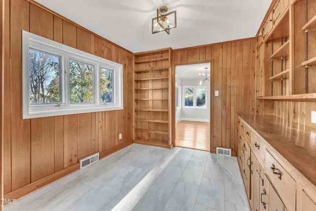 a view of a kitchen with white cabinets and wooden floor
