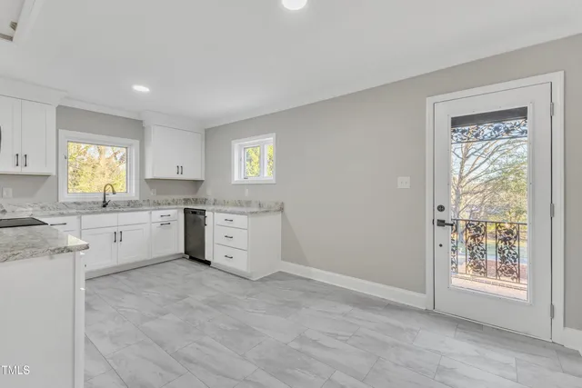 a kitchen with granite countertop white cabinets and white appliances