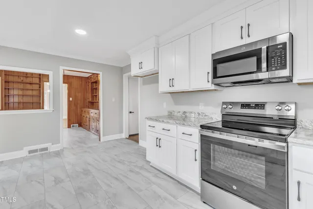 a view of hallway with window and wooden floor