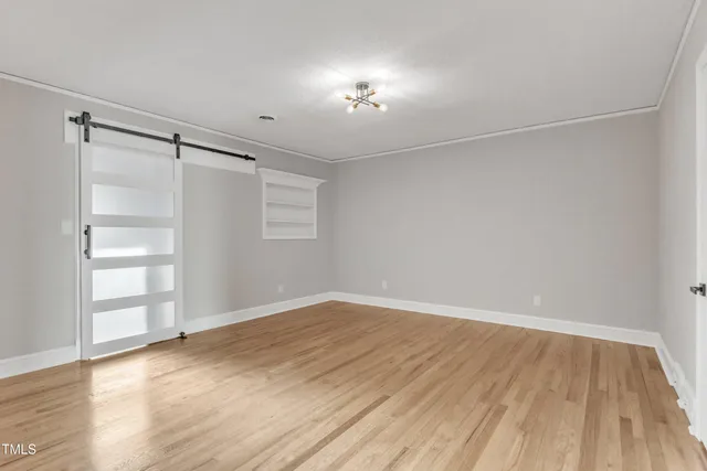 a view of an empty room with wooden floor