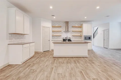a kitchen with stainless steel appliances granite countertop a white cabinets and a refrigerator