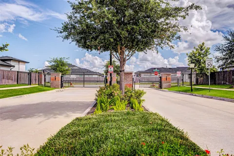 a front view of a house with a big yard and large trees