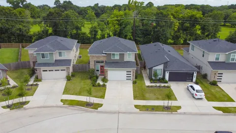 an aerial view of residential houses with outdoor space and swimming pool
