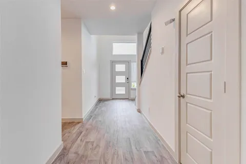 a view of a hallway with wooden floor and staircase