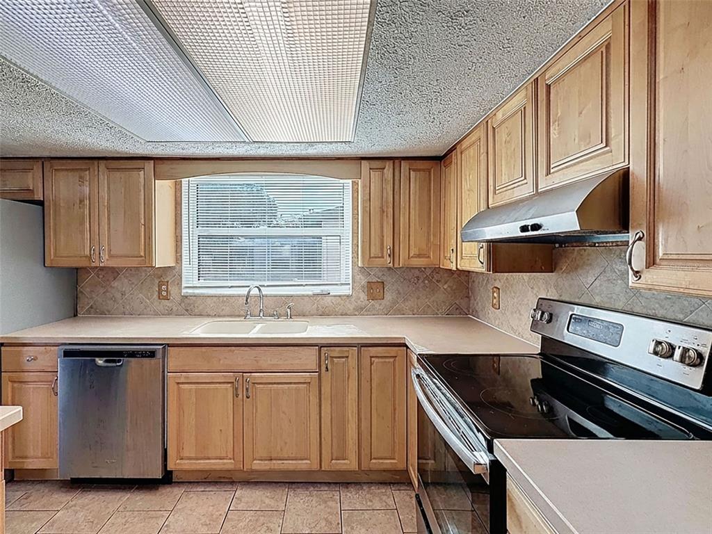 9610 Rainbow Lane Port Richey, FL 34668 - Photo 11 of 34 a kitchen with cabinets appliances a sink and a window