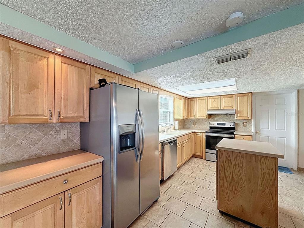 9610 Rainbow Lane Port Richey, FL 34668 - Photo 13 of 34 a kitchen with a refrigerator sink and stove