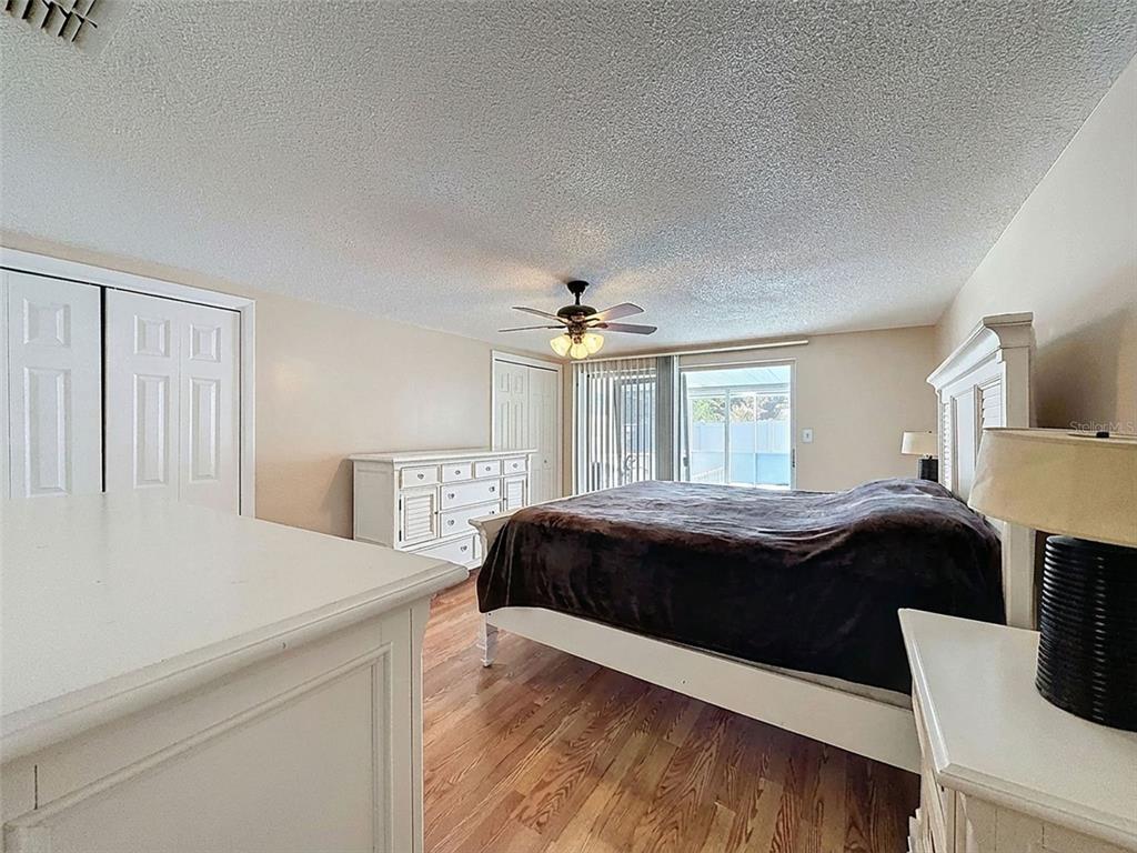 9610 Rainbow Lane Port Richey, FL 34668 - Photo 15 of 34 a bedroom with a bed and a chandelier