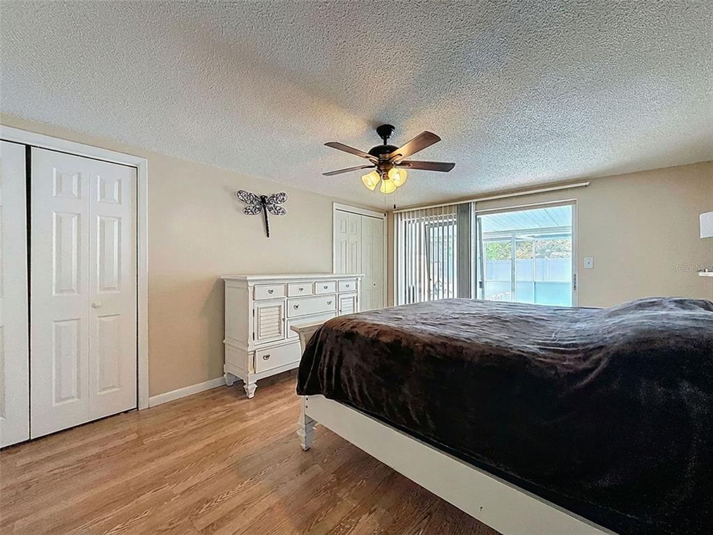 9610 Rainbow Lane Port Richey, FL 34668 - Photo 16 of 34 a bedroom with a bed and a chandelier