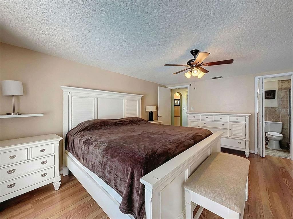 9610 Rainbow Lane Port Richey, FL 34668 - Photo 17 of 34 a bedroom with a bed and a chandelier