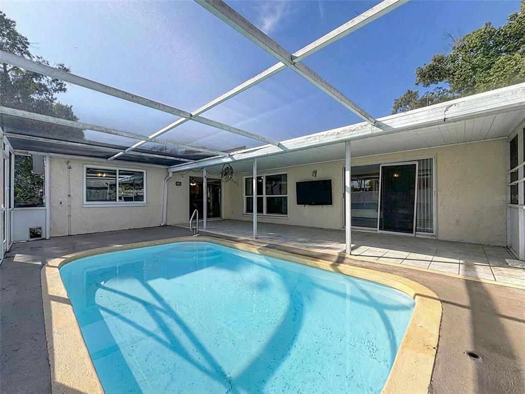 9610 Rainbow Lane Port Richey, FL 34668 - Photo 2 of 34 a view of a house with a swimming pool and sitting area