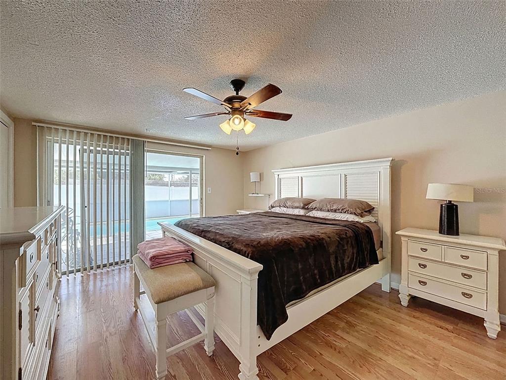 9610 Rainbow Lane Port Richey, FL 34668 - Photo 3 of 34 a bedroom with a bed and a chandelier