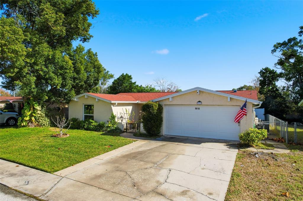 9610 Rainbow Lane Port Richey, FL 34668 - Photo 4 of 34 a view of a white house with a yard and potted plants